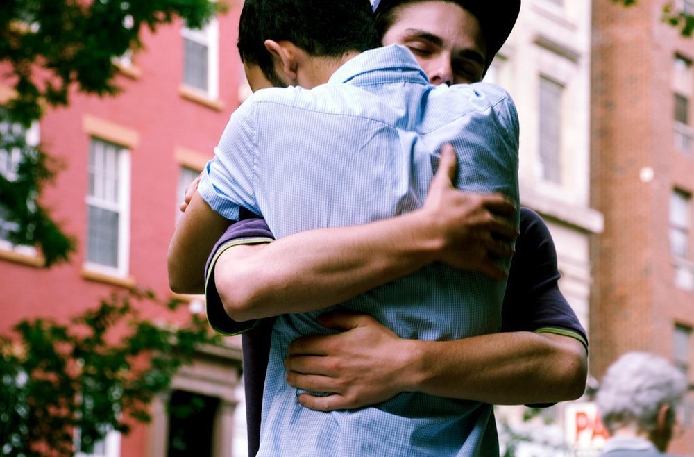 Пацан обнимает пацана. Два парня обнимаются. Парень обнимает парня. Объятия двух мужчин. Объятия друзей.